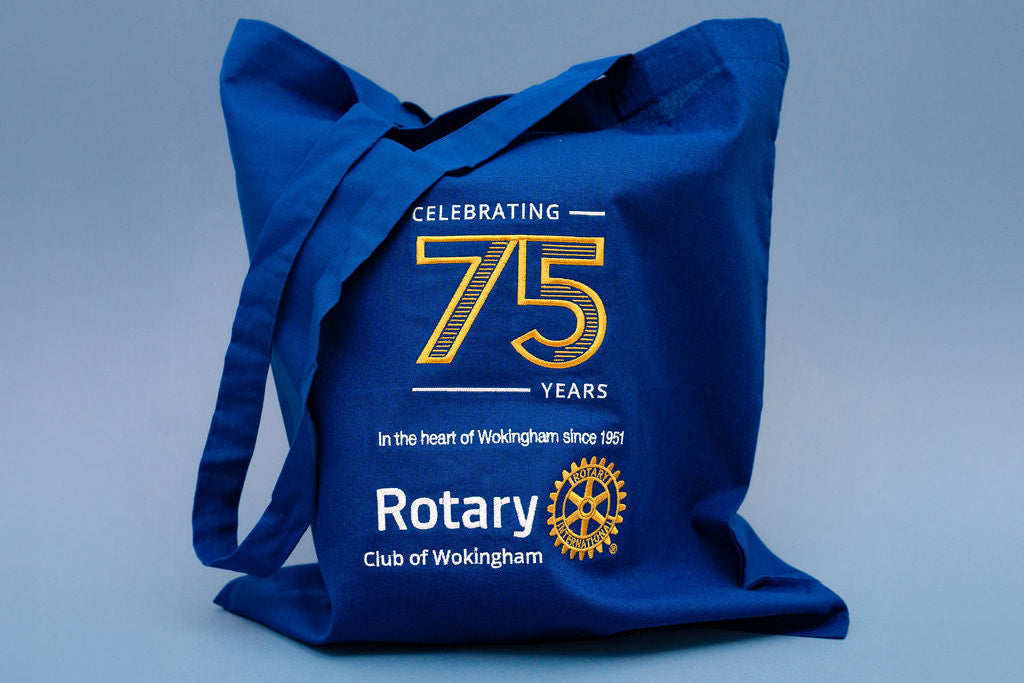 Blue tote bag celebrating 75 years of Rotary Club of Wokingham on a light blue background