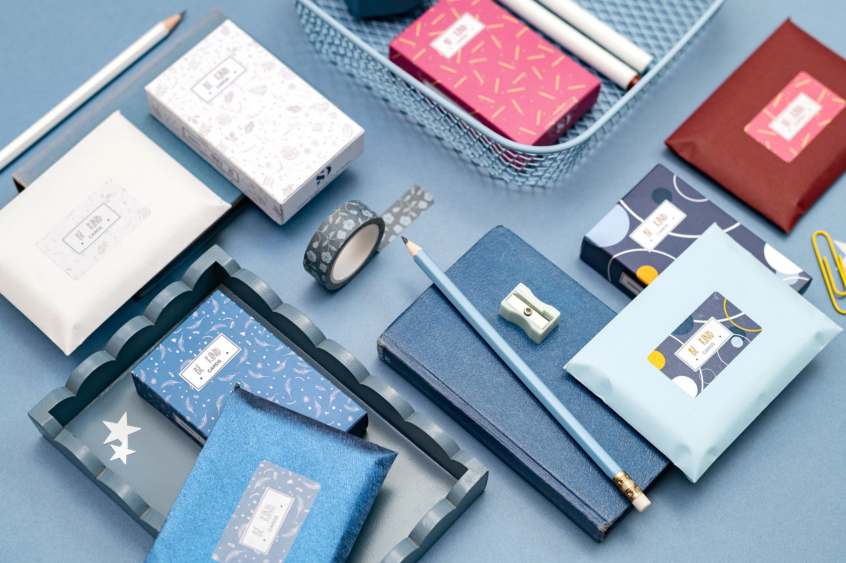 a selection of be kind cards in their packaging surrounding by stationery