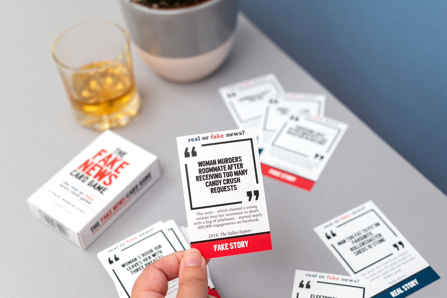Card game with cards on a table next to a glass of whisky