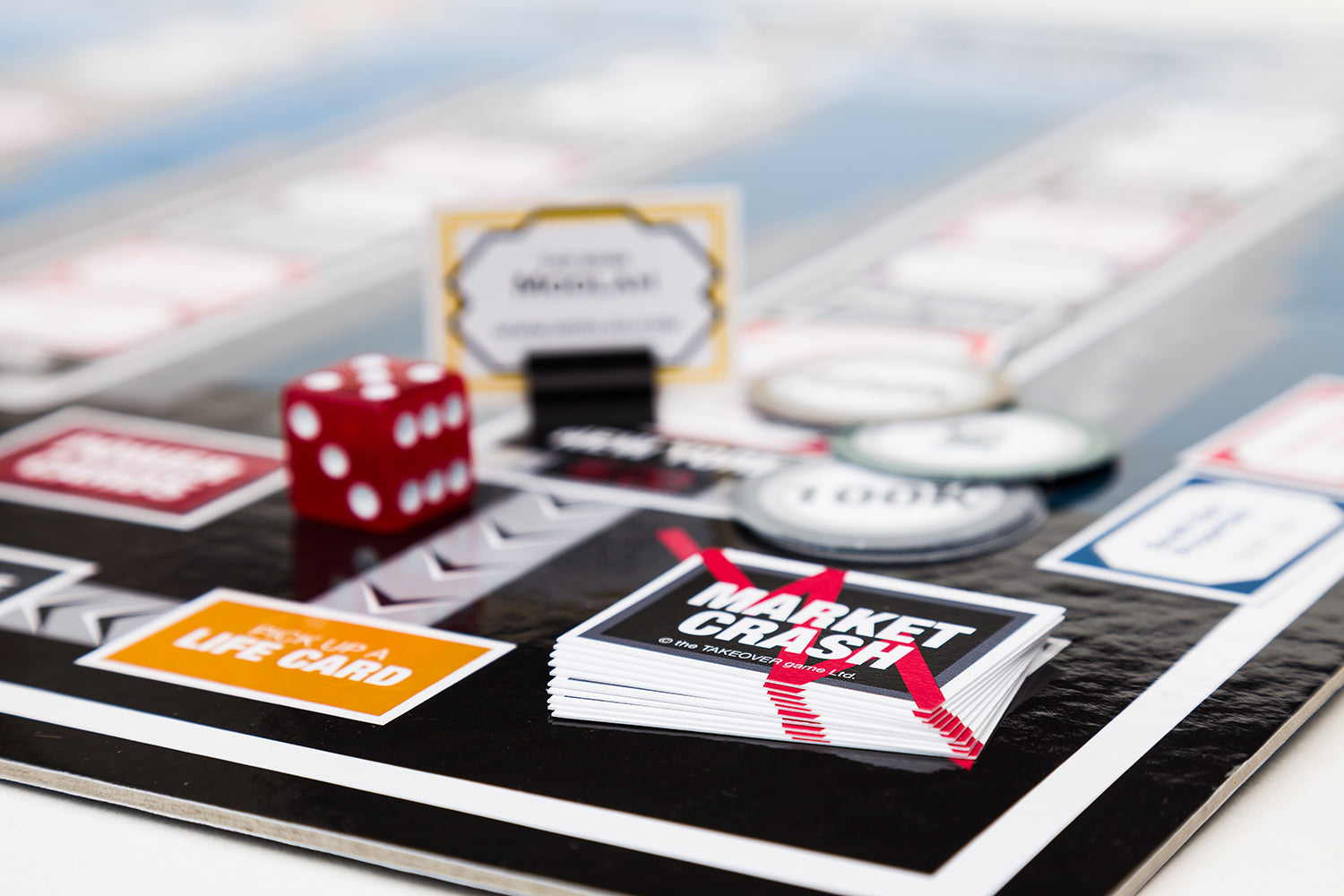 Close-up of the custom currency, property cards, or playing pieces for Takeover.