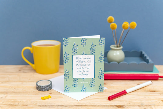 Individual greeting card with quote on surrounded by a cup of tea and stationery.
